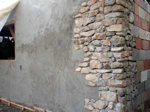Stone, cinderblock and stucco wall.