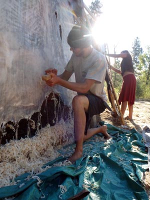 Thinning a buffalo hide with a dry-scrape tool.