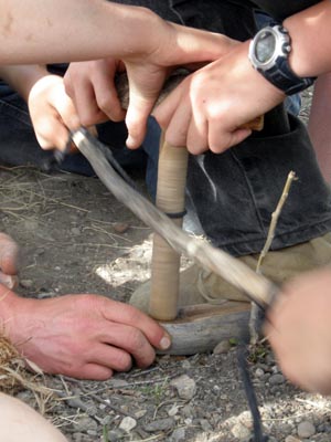 Team bow and drill fire-starting.