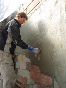 Stuccoing a house.
